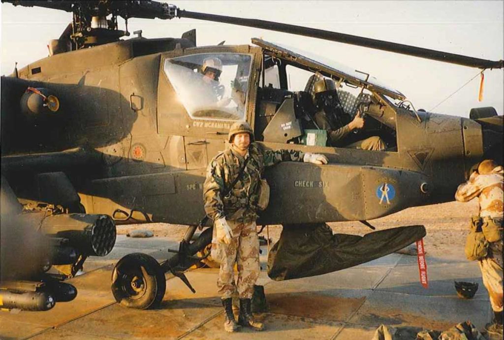 Man next to the apache helicopter